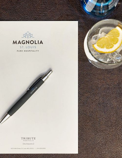 A notepad and pen on a table with a drink and pastry nearby, labeled 