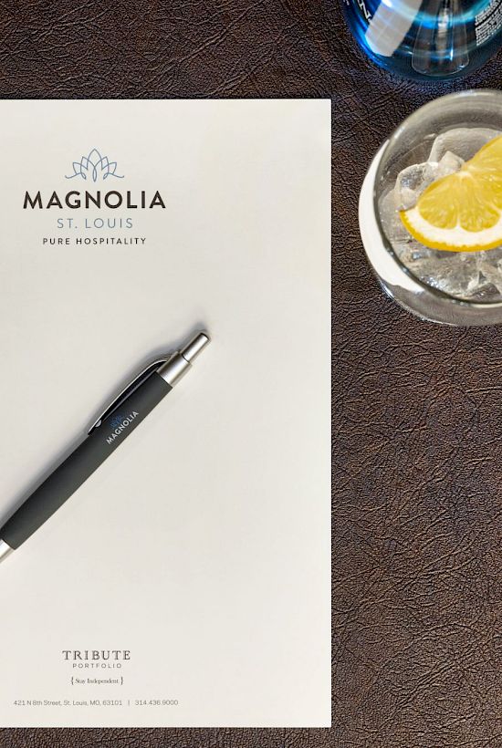 A notepad and pen on a table with a drink and pastry nearby, labeled 