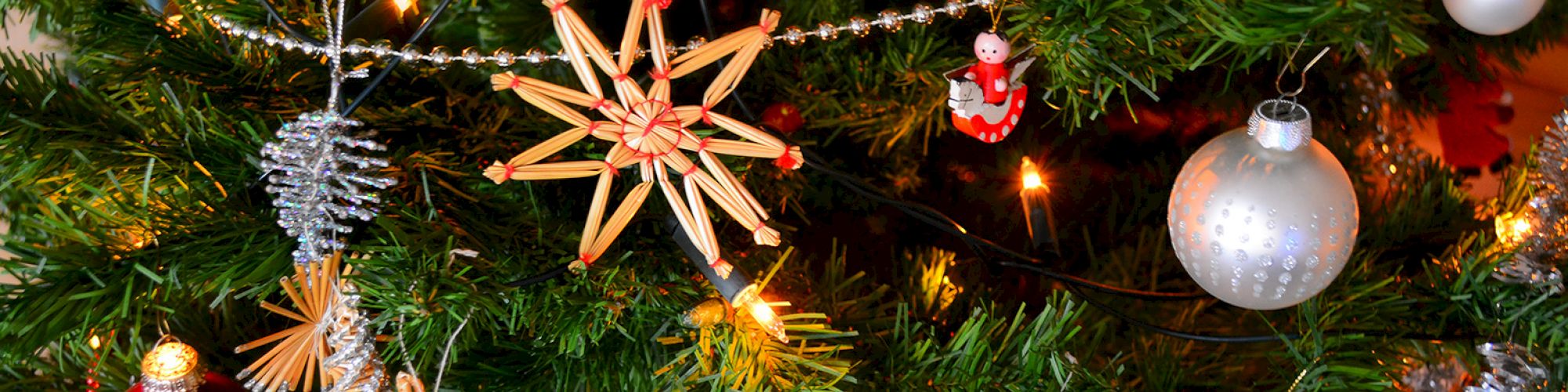 A decorated Christmas tree with ornaments, a star, shiny baubles, and pinecones, creating a festive and colorful holiday atmosphere.