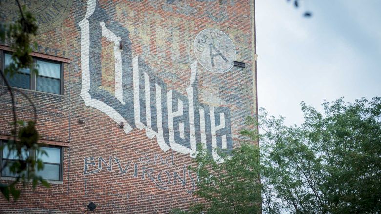 The image shows a building wall mural with the word 