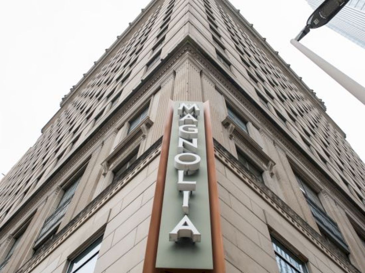 A tall building viewed from below with a sign that reads 